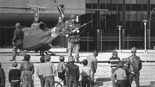 In October 1970, the Quebec government requested the assistance of the Canadian Armed Forces to help protect politicians and important buildings during the October Crisis. Pictured here, children watching soldiers guarding the Quebec Provincial Police headquarters in Montreal.