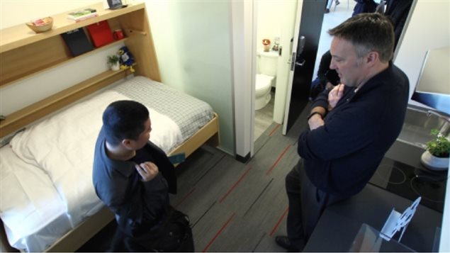 Fold out bed, desk, closet bathroom, sink, two-burner stove, all in 13 square metres. Andrew Parr, UBC’s managing director of student housing and hospitality services, shows nano-studio suite to an interested student in February. The units won’t be ready unitl 2019 however.