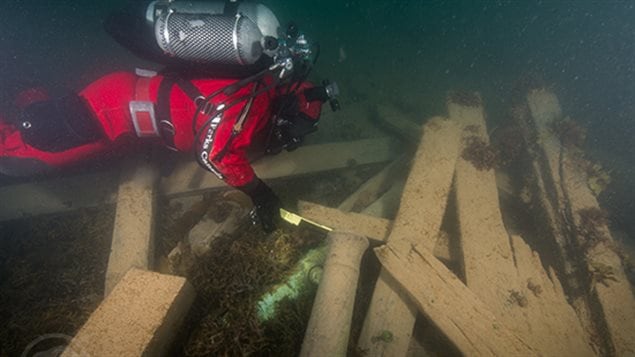 Astern of the wreck of HMS Erebus, Parks Canada underwater archaeologist Filippo Ronca measures the muzzle bore diameter of one of two cannons found on the site, serving to identify this gun as a ’’brass 6-pounder’’