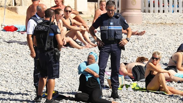 Des policiers français forcent une femme à retirer son burkini. Des policiers français forcent une femme à retirer son burkini.