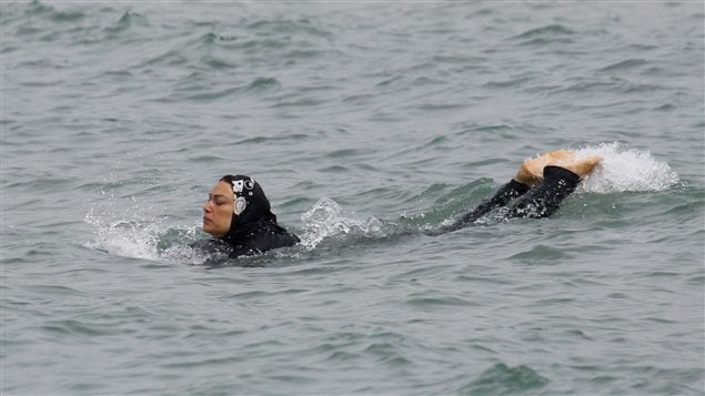 Une femme nage avec un burkini dans une plage de Marseille, en France.