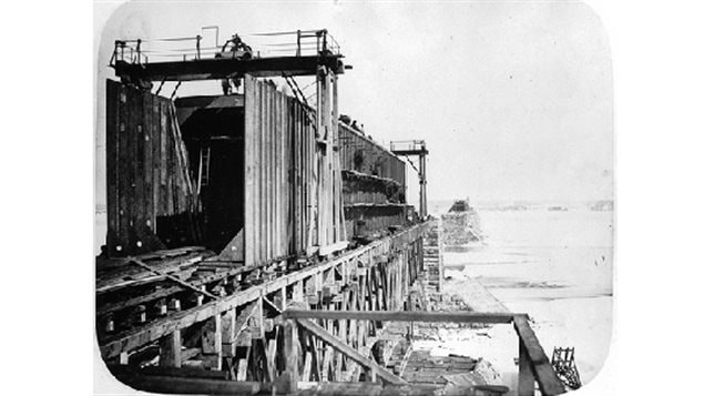Photo showing contruction and assembly of the wrought iron panels shipped from Britain, basically a giant iron box with the train running through the middle