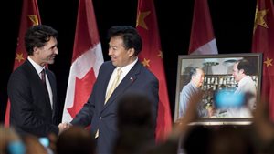 Prime Minister Justin Trudeau shakes hands with China’s Ambassador to Canada Luo Zhaohui (right) after being presented a photo of his father, former Prime Minister Pierre Elliot Trudeau, meeting Chairman Mao Zedong, during a celebration of 45 years of Canada-China diplomatic relations, in Ottawa on Jan. 27, 2016.