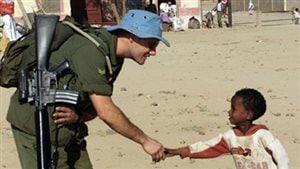 A Canadian soldier meets a young Eritreanduring a familiarization patrol north of the TemporarySecurity Zone, as part of Operation Eclipse,Canada’s contribution to United Nations Mission inEthiopia and Eritrea, 2001. 