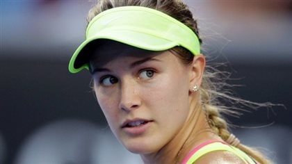 Eugenie Bouchard continues the hunt for her game that's pretty much gone missing over the last two years. We see her looking backwards with a slightly bewildered look in her eyes. Her blond hair is in a braid. She wears a yellow cap.