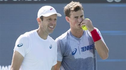 There's talk that Daniel Nestor (left) and Vasek Pospisil have a legitimate shot at the men's doubles title in New York. We see the two sweating and planning strategy with Nestor smiling and Pospisil speaking behind a pair of yellow tennis balls he holds in his left hand.