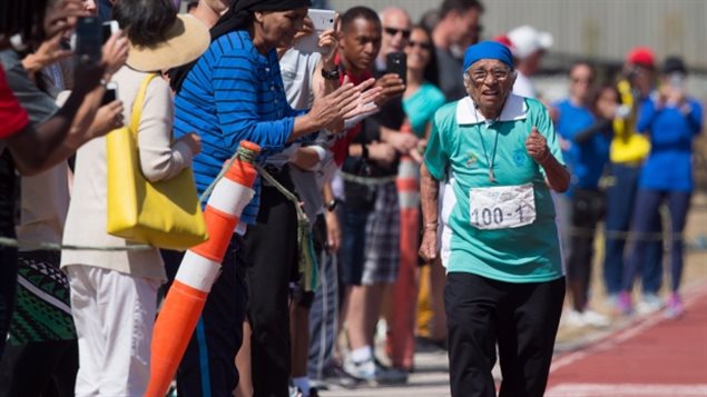 Man Kaur won nothing but cheers in winning her racing gold on Monday. We see dozens of younger people clapping and cheering as Kaur runs in a light green long-sleeved shirt and dark long pants. She wears a blue head covering.
