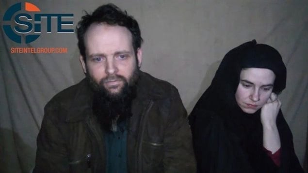 Canadian Joshua Boyle and his wife, American Caitlan Coleman, are shown in this still image taken from a video which appears to have been released by the Taliban in Afghanistan. We see Boyle on the left. He has a long beard, very depressed eyes and wears a suede jacket. Coleman is behind him at the right of the picture. She is dressed in all black, including a black head covering. She is looking down and appears very, very sad.
