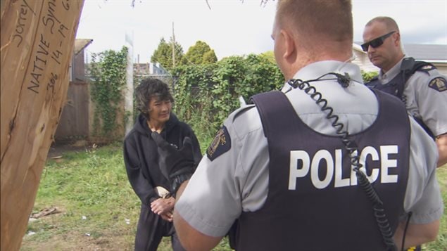 警官乔什.沃特曼和特瑞弗. 丁伍迪在询问瘾君子