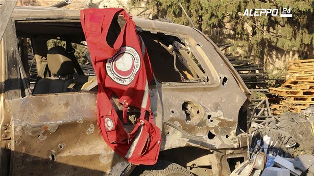  This image provided by the Syrian anti-government group Aleppo 24 news, shows a vest of the Syrian Arab Red Crescent hanging on a damaged vehicle, in Aleppo, Syria, Tuesday, Sept. 20, 2016. 