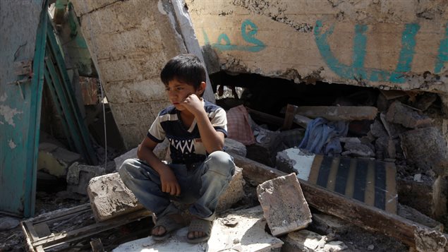 Un niño sentado en los escombros de su casa destruida por los ataques aéreos del ejército de Arabia Saudita a la capital de Yemen Sana’a / Septiembre 2016