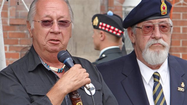 War hero Charles Byce’s son’s, Richard Byce (L) and Frank Byce (R) speak at the ceremony to commemorate their father. In the background: a member of Lake Superior Scottish Regiment Guard of Honour