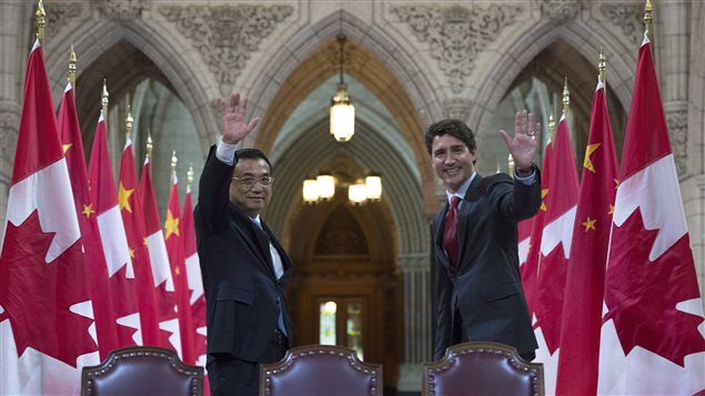 Canadian Prime Minister Justin Trudeau and Chinese Premier Li Keqiang wave to photographers following a signing ceremony in the Hall of Honour on Parliament Hill in Ottawa, Thursday September 22, 2016.