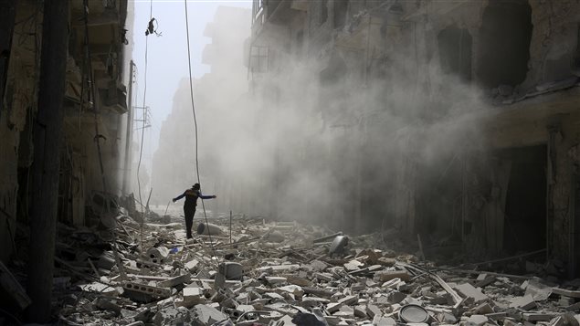 رجل يسير وسط الركام في احد أحياء حلب