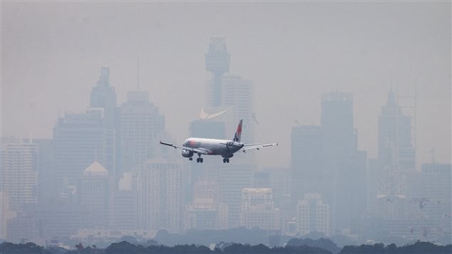 An Australian commercial aircraft prepares to land in the haze at Sydney’s International Airport July 15, 2014.