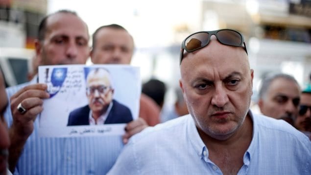 Majed Hattar, right, brother of the Jordanian writer Nahed Hattar, speaks to the media during a sit-in in Al-Fuheis