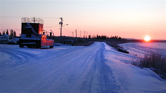 Coucher du soleil aux bords du fleuve Mackenzie près d’Inuvik, dans les T.N-O Northwest Territories où on perçoit aussi de l’équipement pétrolier.