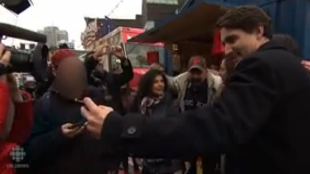 Newly elected Canadian Prime Minister Justin Trudeau poses for selfies with a crowd in Montreal in Dec 2015.  The man in question is seen very close to him in this image