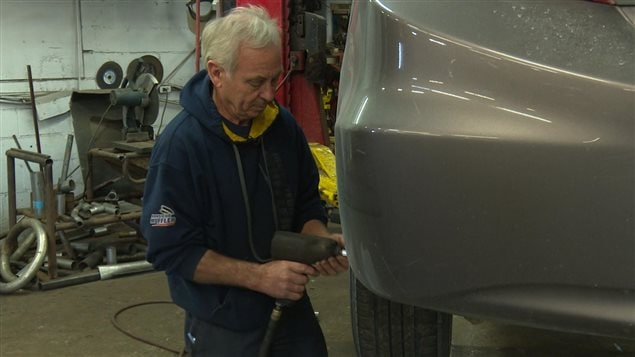 Un mecánico canadiense cambiando las ruedas de un auto.