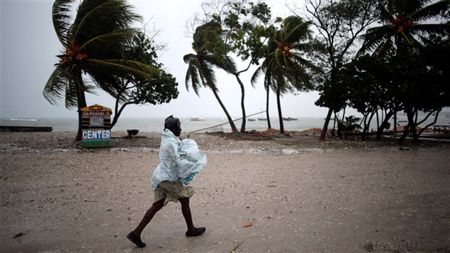  A woman protects herself from rain as Hurricane Matthew approaches in Les Cayes, Haiti, October 3, 2016. 