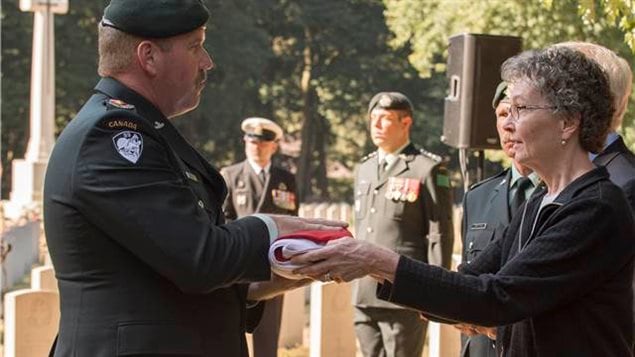  Lieutenant Colonel Ken McClure, Commanding Officer of The Algonquin Regiment, hands the Canadian Flag to Judith Thomas, a second cousin of Private Kenneth Duncanson during a burial ceremony at the Adegem Canadian War Cemetery, near Brugge, Belgium, on September 14, 2016. Private Duncanson died exactly 72 years ago during the Second World War