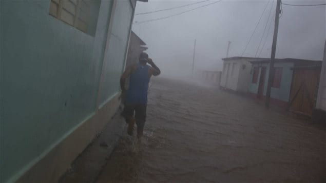 Un résident de Baracoa, à Cuba, marche dans une rue inondée, le 4 octobre