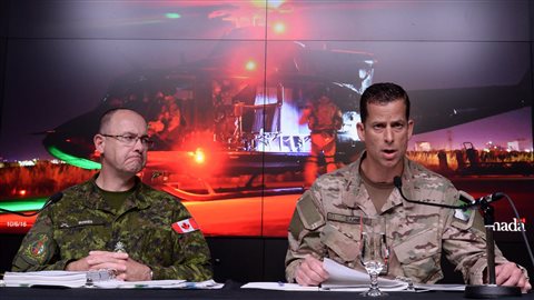 中将斯蒂芬·鲍斯（左）和准将彼得·达维在渥太华国防部记者招待会上发言。