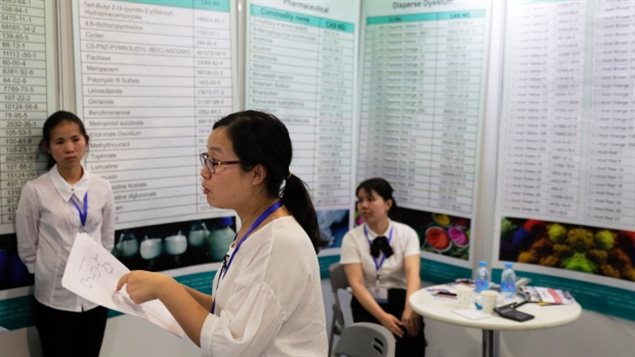 Xu Liqun, centre, president of Hangzhou Reward Technology, speaks at the company’s booth during the China International Chemical Industry Fair in Shanghai on Sept. 21. Liqun said her company could produce carfentanil to order. (Andy Wong/The Associated Press