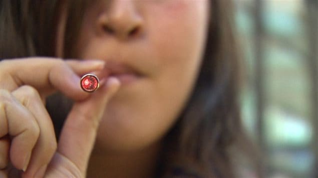 Une femme fume une cigarette électronique
