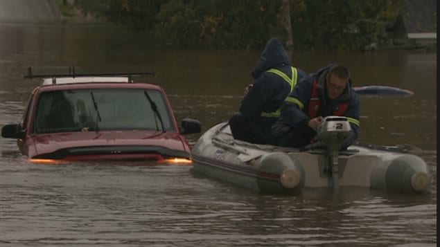 emergency crew comes to the aid of  people in a vehicle caught in the sudden flood in Sydney, N.S