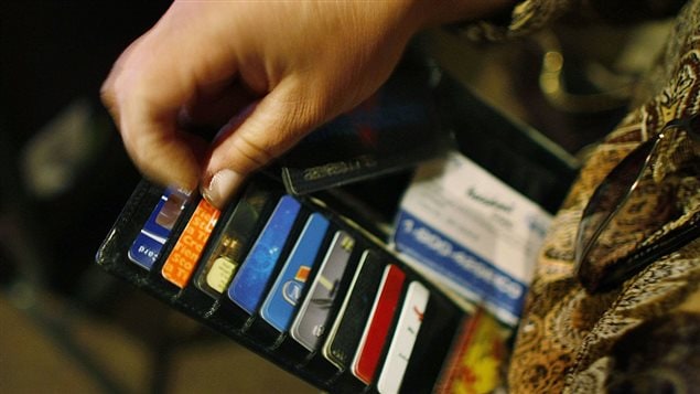 Une femme regarde ses cartes de crédit et d’identification dans son portefeuille