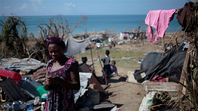 A woman stands by her house as she cooks after Hurricane Matthew in Les Anglais, Haiti, October 13, 2016. 