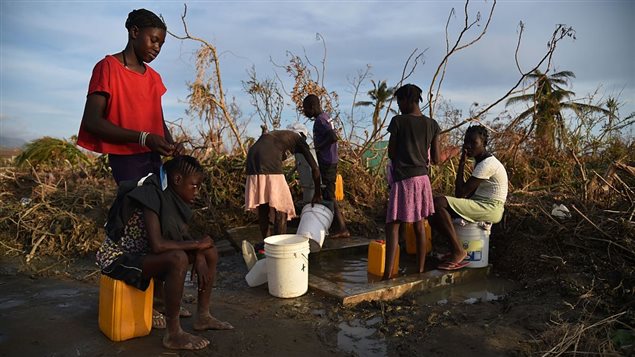 Haitians pump water from a cistern next to the road, in the commune of Chadonyer, in Les Cayes, in the south west of Haiti, October 11, 2016.