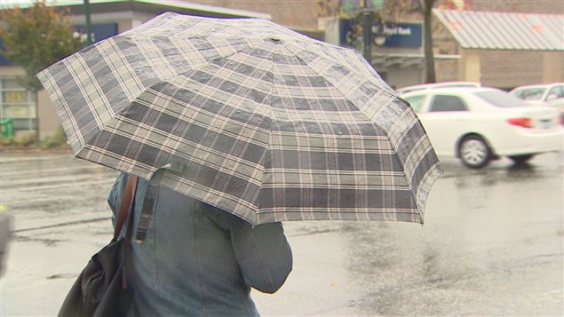 Un piéton se protège de la pluie à Vancouver.