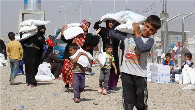 People who fled the Islamic State’s strongholds of Hawija and Mosul, receive aid at a camp for displaced people in Daquq, Iraq, October 13, 2016. 