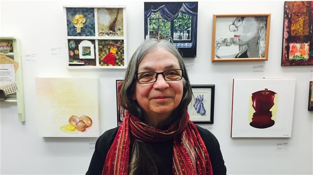 La fondatrice du musée d’art de la femme d’Edmonton Danielle LaBrie pose devant des oeuvres.