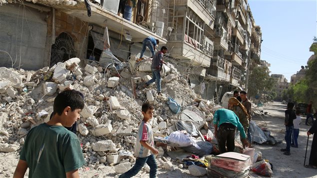 People remove belongings from a damaged site after an air strike Sunday in the rebel-held besieged al-Qaterji neighbourhood of Aleppo, Syria October 17, 2016.