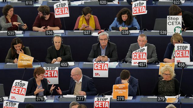 Members of the Confederal Group of the European United Left of the European Parliament display posters with the words *stop CETA* as they take part in a voting session at the European Parliament in Strasbourg, France, October 26, 2016.