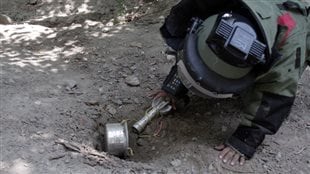 An Afghan soldier searches for landmines with a metal detector in a training exercise in 2014. There are still 50 to 100 million active landmines around the world.