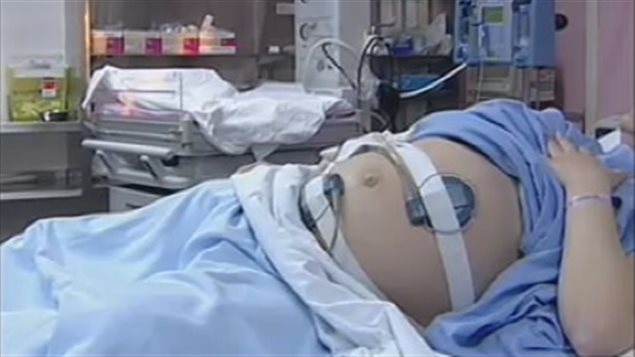 Une femme enceinte sur un lit d’hôpital