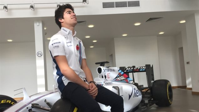 Lance Stroll sits on the tire of a Formula One car at the announcement of his addition to the Williams racing team in Oxfordshire, England, Thursday. A dream come true* he said