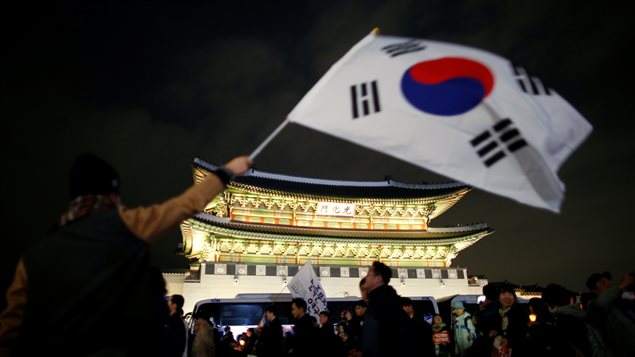 Un manifestante agita una bandera de Corea del Sur frente a la Casa Azul, la sede presidencial.