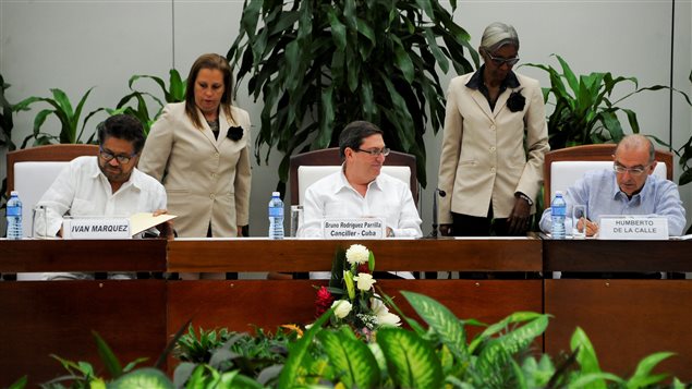 El jefe de la delegación de las FARC Iván Márquez (izq) y el jefe negociador del gobierno colombian Humberto de la Calle (der) firman el nuevo acuerdo de paz en presencia del ministro de Relaciones Exteriores de Cuba, Bruno Rodríguez Parrilla (centro) en La Habana, Cuba, este sábado 12 de noviembre 2016.