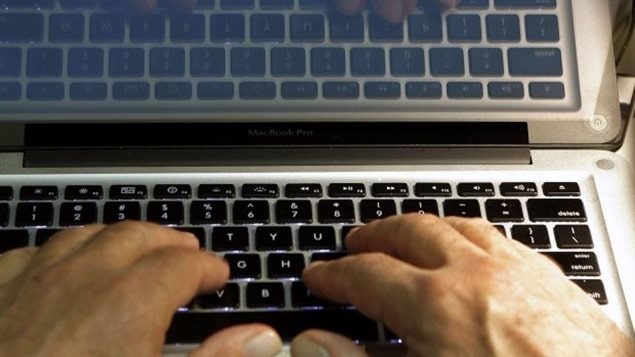 Un homme tape sur un clavier d’ordinateur portable 
