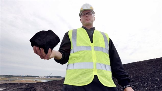 A worker holds a piece of coal destined for a coal-fired power plant. The federal government announced plans Monday to take the country’s coal plants offline by 2030, which is expected to result in a reduction of roughly 61 megatonnes of annual emissions. (Rogelio V. Solis/AP Photo