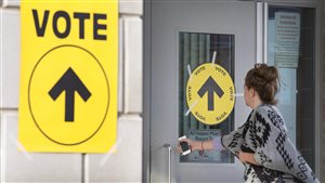 A woman enters Maple High School in Vaughan, Ont., to cast her vote in the Canadian federal election on Monday, Oct. 19, 2015.