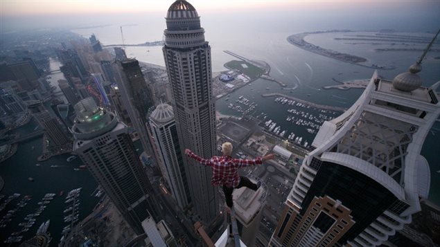 Oleg Cricket balances on one foot at a dizzying height in Dubai 