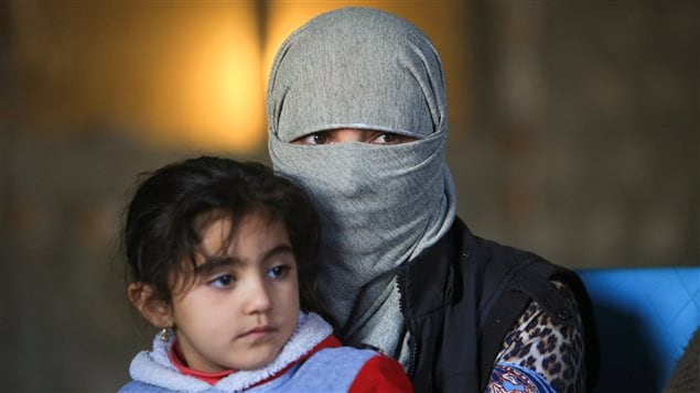 A displaced woman from the minority Yazidi sect, who was kidnapped by Islamic State militants of Tal Afar but managed to flee, holds a child in Duhok province, northern Iraq, November 24, 2016.