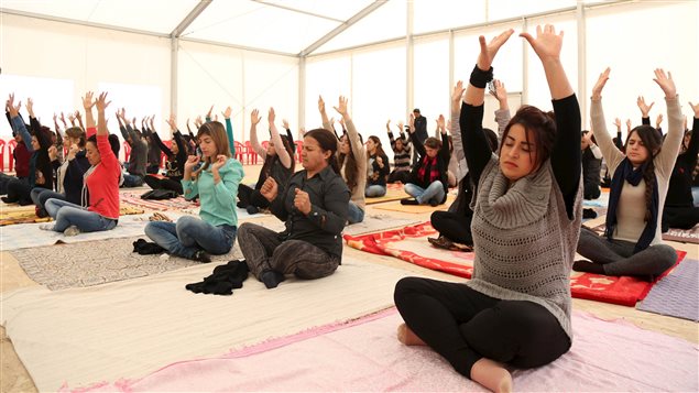 Displaced women from the minority Yazidi sect, who fled violence in the Iraqi town of Sinjar, practice yoga at Sharya refugee camp on the outskirts of Duhok province, December 16, 2015.