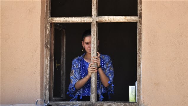 A displaced woman from the minority Yazidi sect, fleeing violence in Iraq, looks out from an abandoned house where she is taking refuge in the southeastern Turkish town of Silopi, near the Turkish-Iraqi border crossing of Habur, August 13, 2014.